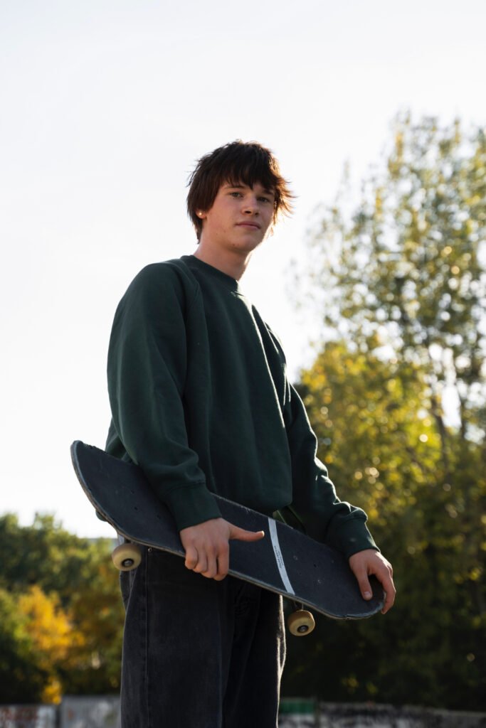 Hombre modelo posando con ropa streetwear en un fondo parecido a un parque.