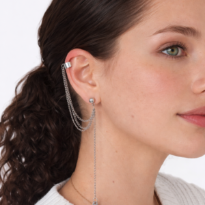 Perfil de mujer joven con coleta rizada y pendientes ear cuff plateados con cadenas de la marca Urban Mirage, estilo streetwear sobre fondo neutro. Imagen generada por IA.